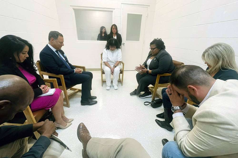 In this April 6, 2022 photo provided by Texas state Rep. Jeff Leach, Texas death row inmate Melissa Lucio, dressed in white, leads a group of seven Texas lawmakers in prayer in a room at the Mountain View Unit in Gatesville, Texas. The lawmakers visited Lucio to update her about their efforts to stop her April 27 execution. The lawmakers say they are troubled by Lucio’s case and believe her execution should be stopped as there are legitimate questions about whether she is guilty. (Texas state Rep. Jeff Leach via AP)/TXHO201/22097735839518/AP PROVIDES ACCESS TO THIS PUBLICLY DISTRIBUTED HANDOUT PHOTO PROVIDED BY [SOURCE GOES HERE]; MANDATORY CREDIT./2204072239
